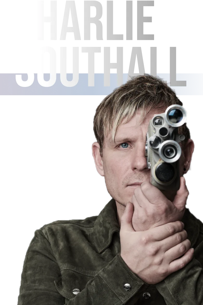 A Person With Blonde Hair Is Holding And Looking Through The Viewfinder Of A Vintage Movie Camera. Dressed In A Green Jacket, They Seem Focused And Creative. The Name &Quot;Charlie Southall&Quot; Is Written In Large Bold Letters At The Top Of The Image, Inviting You To Meet The Dragonfly Team. A person with blonde hair is holding and looking through the viewfinder of a vintage movie camera. Dressed in a green jacket, they seem focused and creative. The name "Charlie Southall" is written in large bold letters at the top of the image, inviting you to meet the Dragonfly Team.