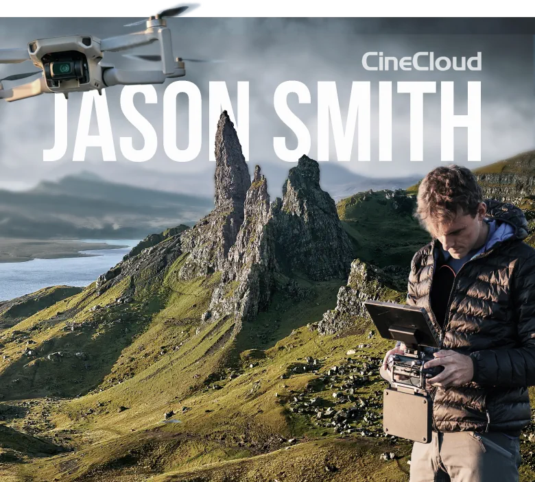 A Person Operates A Drone'S Remote Control In A Hilly, Green Landscape With Prominent Rock Formations Under A Cloudy Sky. The Text &Quot;Cinecloud&Quot; And &Quot;Jason Smith&Quot; Is Displayed At The Top Of The Image, Inviting You To Meet The Team. A Drone From The Dragonfly Team Is Seen Flying In The Upper Left Corner. A person operates a drone's remote control in a hilly, green landscape with prominent rock formations under a cloudy sky. The text "CineCloud" and "Jason Smith" is displayed at the top of the image, inviting you to meet the team. A drone from the Dragonfly Team is seen flying in the upper left corner.
