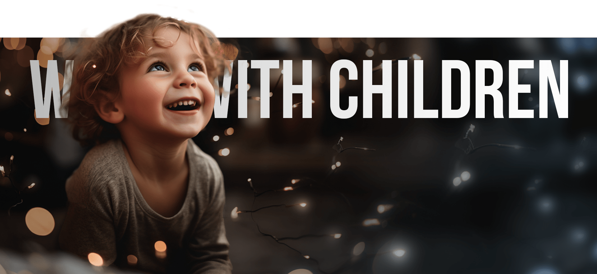 A Young Child With Curly Hair Smiles And Looks Upward, Captured In A Moment Of Wonder. In The Background, String Lights Create A Warm Ambiance. Overlaid Text Reads &Quot;With Children.&Quot; The Top Of The Image Includes A Green Bar. A young child with curly hair smiles and looks upward, captured in a moment of wonder. In the background, string lights create a warm ambiance. Overlaid text reads "With Children." The top of the image includes a green bar.
