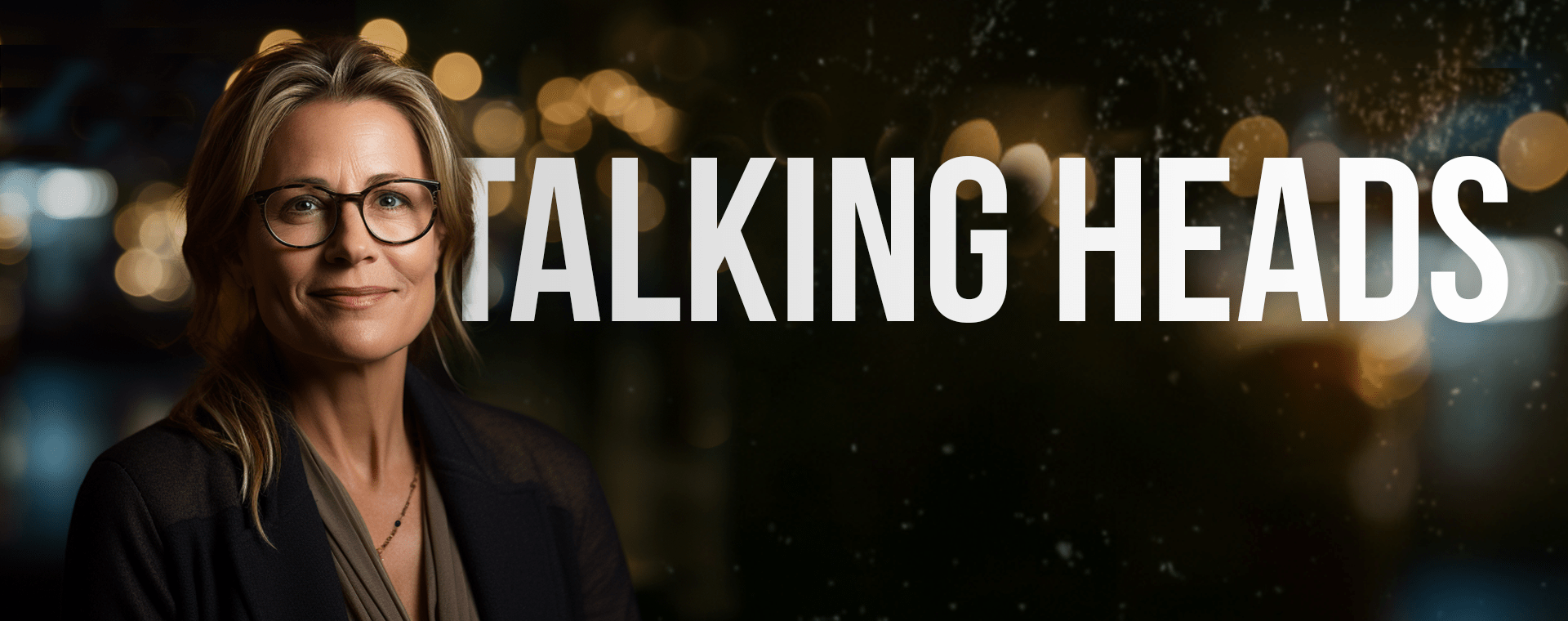 An Individual With Glasses And A Warm Smile Is Shown On The Left Side Of The Image, Against A Dark, Blurred Bokeh Background With Golden Lights. The Text &Quot;Talking Heads&Quot; Is Prominently Displayed In Large Letters On The Right Side. An individual with glasses and a warm smile is shown on the left side of the image, against a dark, blurred bokeh background with golden lights. The text "TALKING HEADS" is prominently displayed in large letters on the right side.